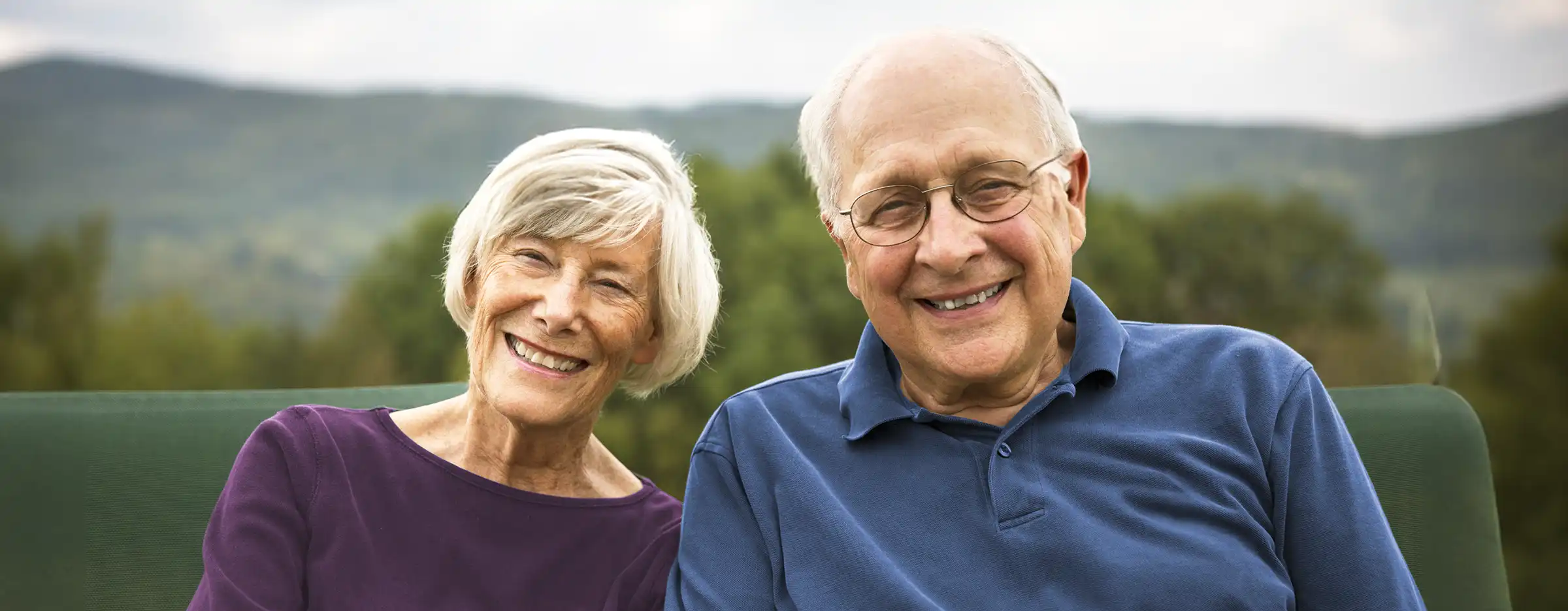 Couple sitting outdoors smiling