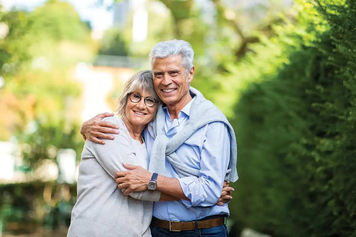 A senior couple embrace together outdoors