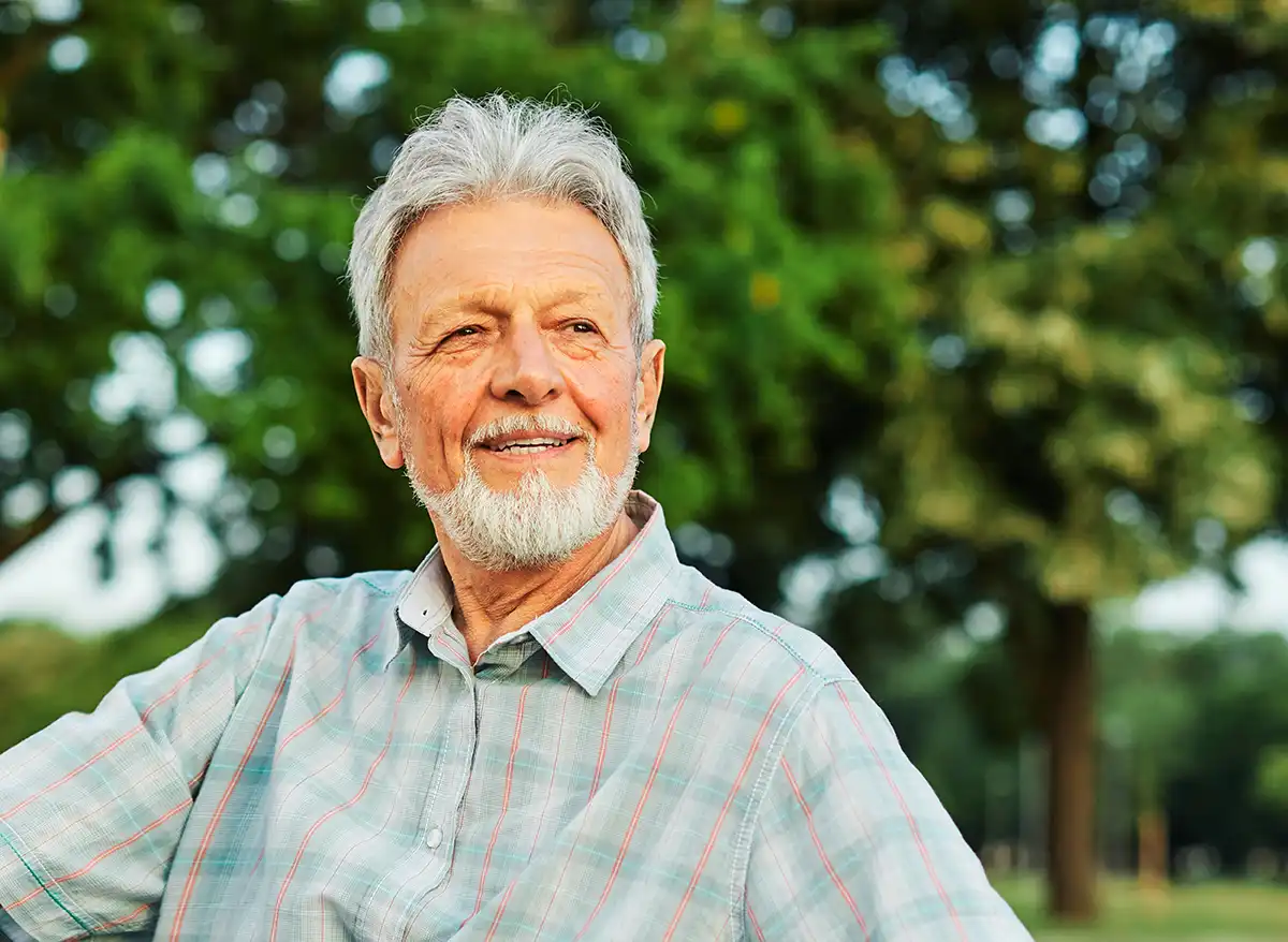 A senior man looks toward the rising sun