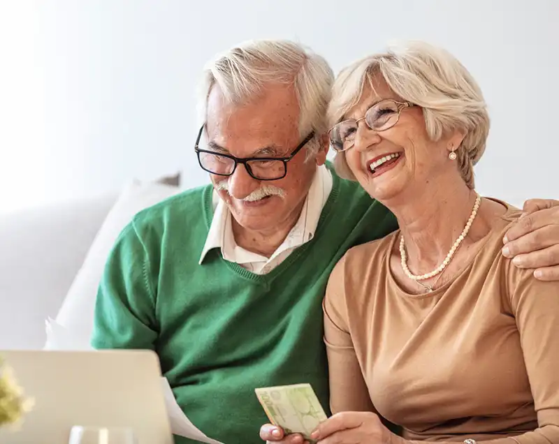 Couple smiling on their laptop