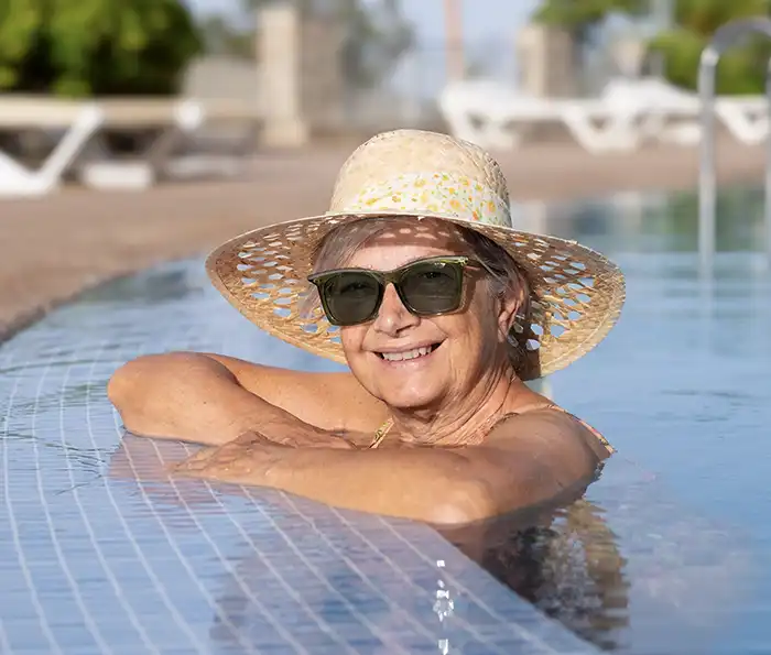 Woman in hat and sunglasses in the pool